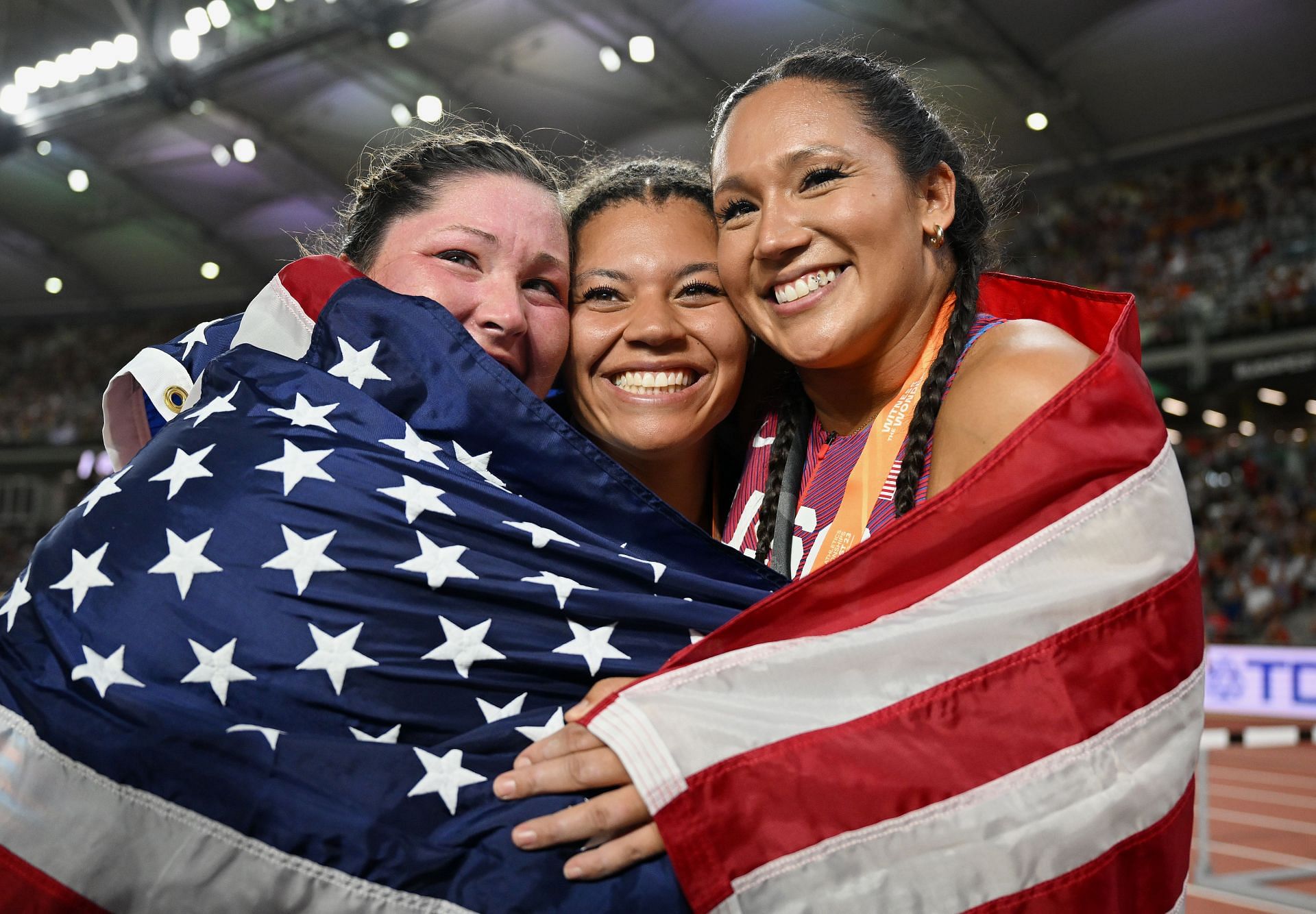 Bronze medalist Deanna Price of Team United States, gold medalist Camryn Rogers of Team Canada and silver medalist Janee' Kassanavoid of Team United States react after winning the Women's Hammer Throw Final during Day 6 of the World Athletics Championships Budapest 2023