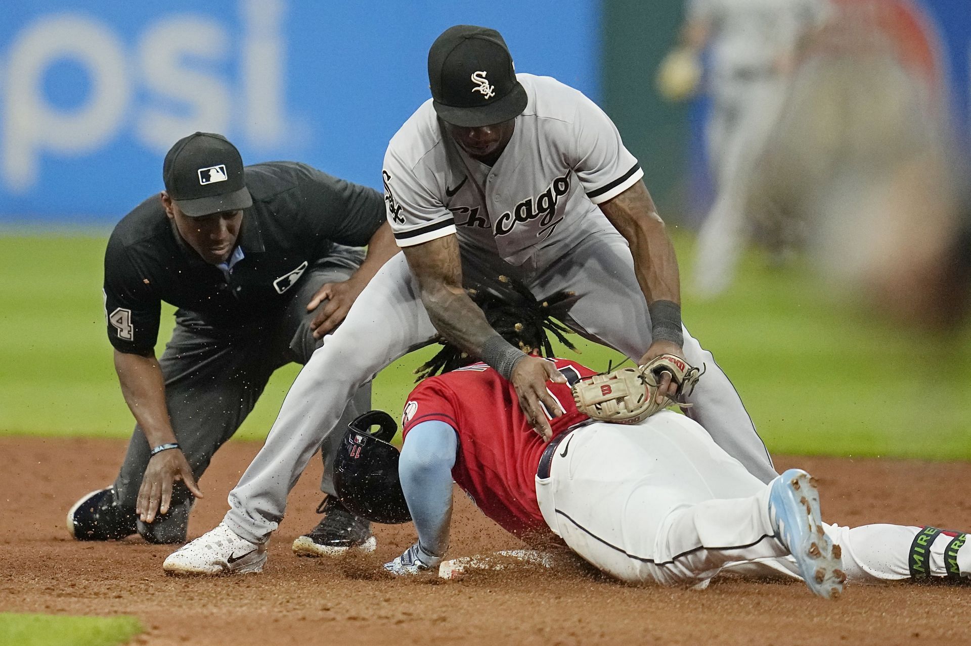 Second base umpire Malachi Moore, left, watches as Cleveland Guardians&#039; Jose Ramirez, bottom right, slides under the legs of Chicago White Sox shortstop Tim Anderson, top right, in the sixth inning of a baseball game Saturday, Aug. 5, 2023, in Cleveland. (AP Photo/Sue Ogrocki)