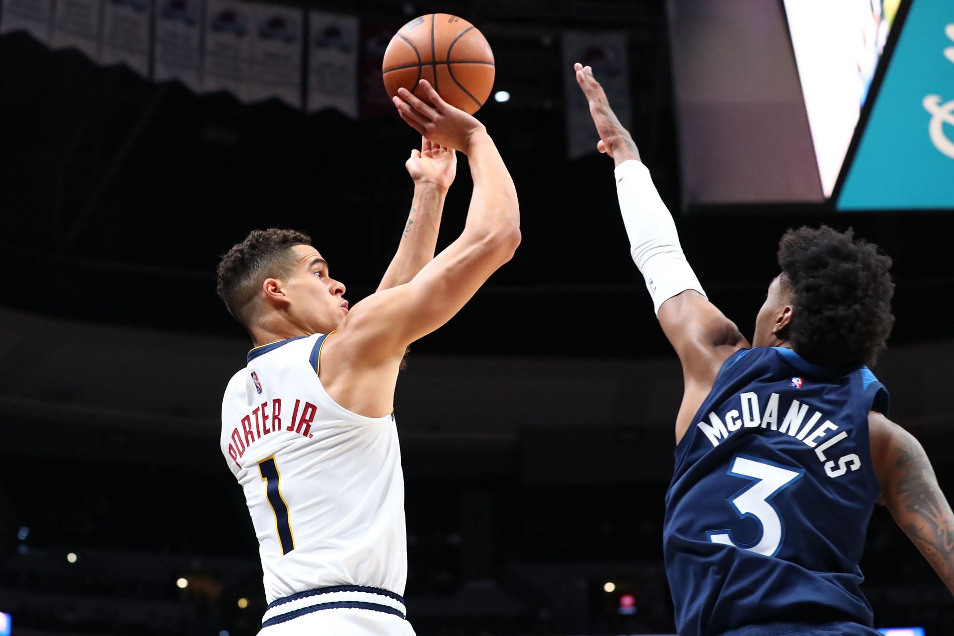 Jaden McDaniels of the Minnesota Timberwolves contests a three-point attempt by Michael Porter Jr. of the Denver Nuggets