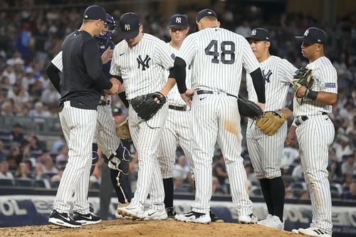 New York Yankees manager Aaron Boone, left, removes pitcher Clarke Schmidt against the Kansas City Royals