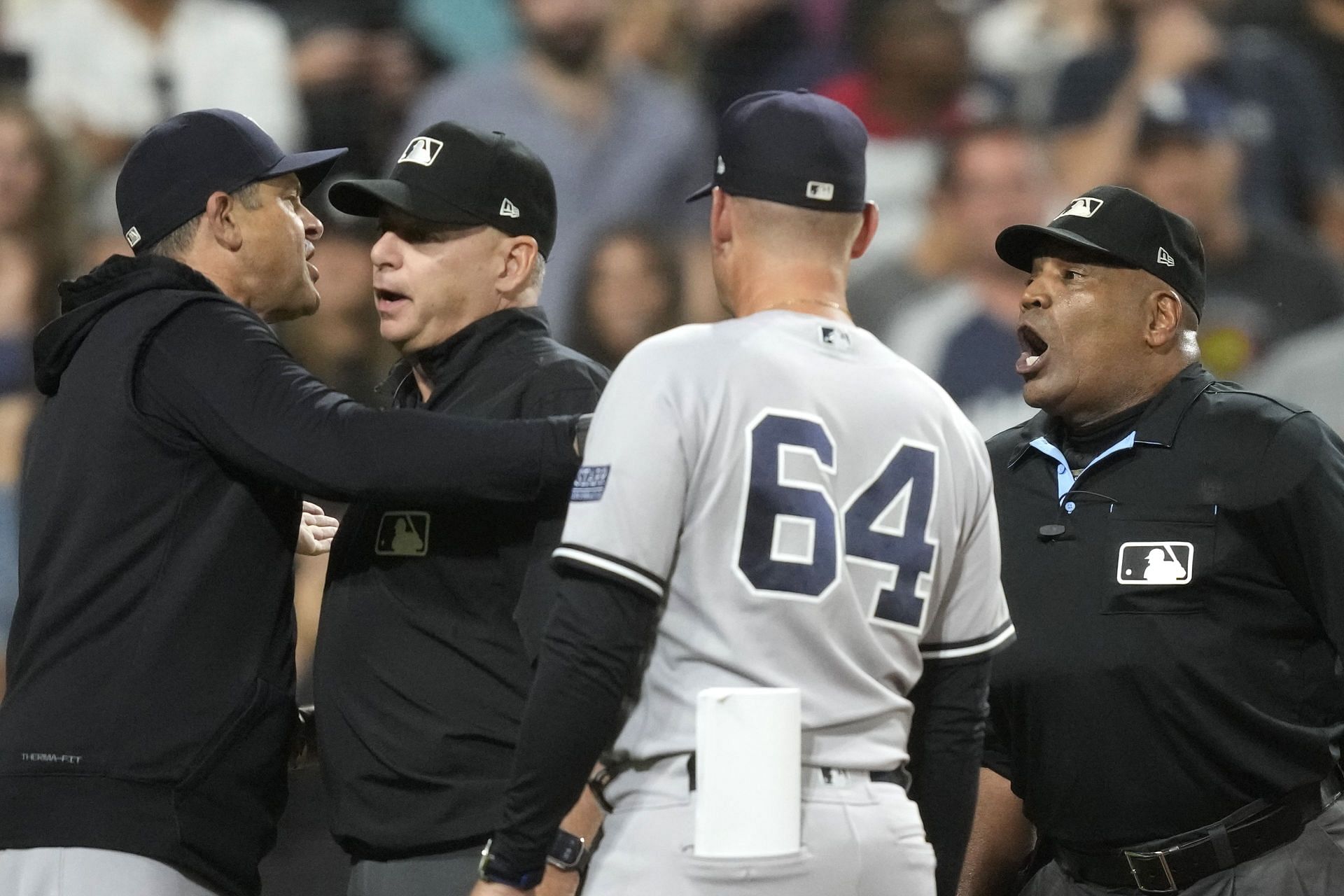 New York Yankees manager Aaron Boone, left, continues to argue with home plate umpire Laz Diaz, right, as second base umpire Andy Fletcher and bench coach Carlos Mendoza (64) stabs between them during the eighth inning of a baseball game against the Chicago White Sox Monday, Aug. 7, 2023, in Chicago. (AP Photo/Charles Rex Arbogast)