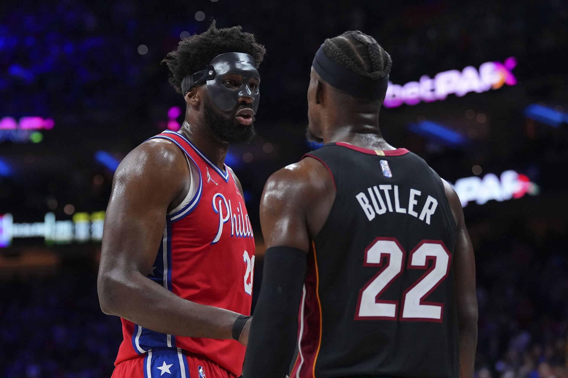 Joel Embiid of the Philadelphia 76ers talks to Jimmy Butler of the Miami Heat.