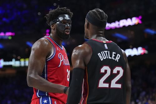 Joel Embiid of the Philadelphia 76ers talks to Jimmy Butler of the Miami Heat.