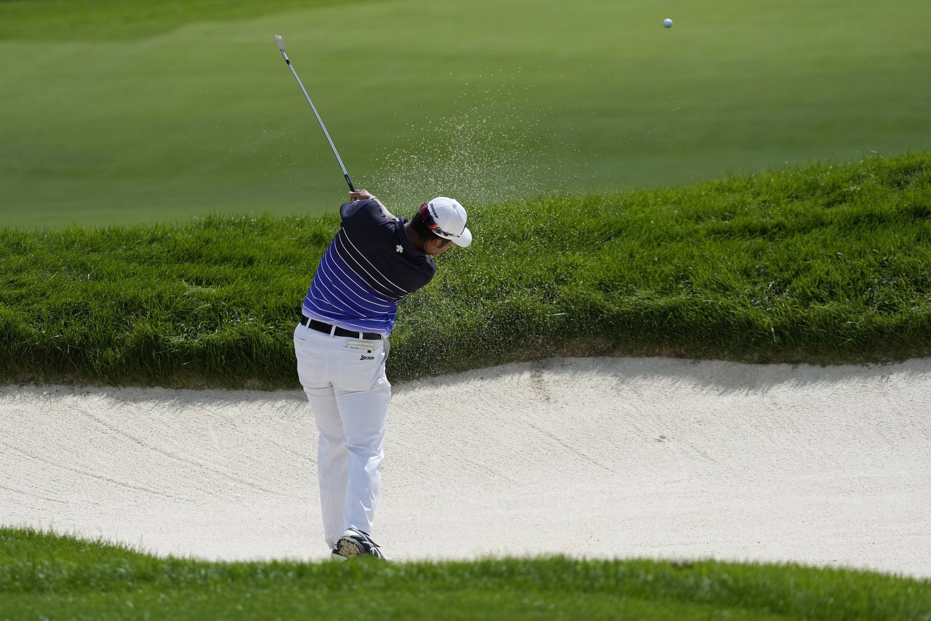 Hideki Matsuyama clears the far wall of a bunker in his second attempt on the ninth fairway during the first round of the 2023 BMW Championship