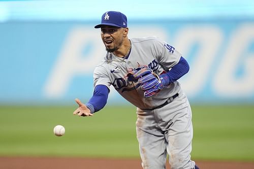 Los Angeles Dodgers second baseman Mookie Betts tosses the ball for the out on Cleveland Guardians' Kole Calhoun