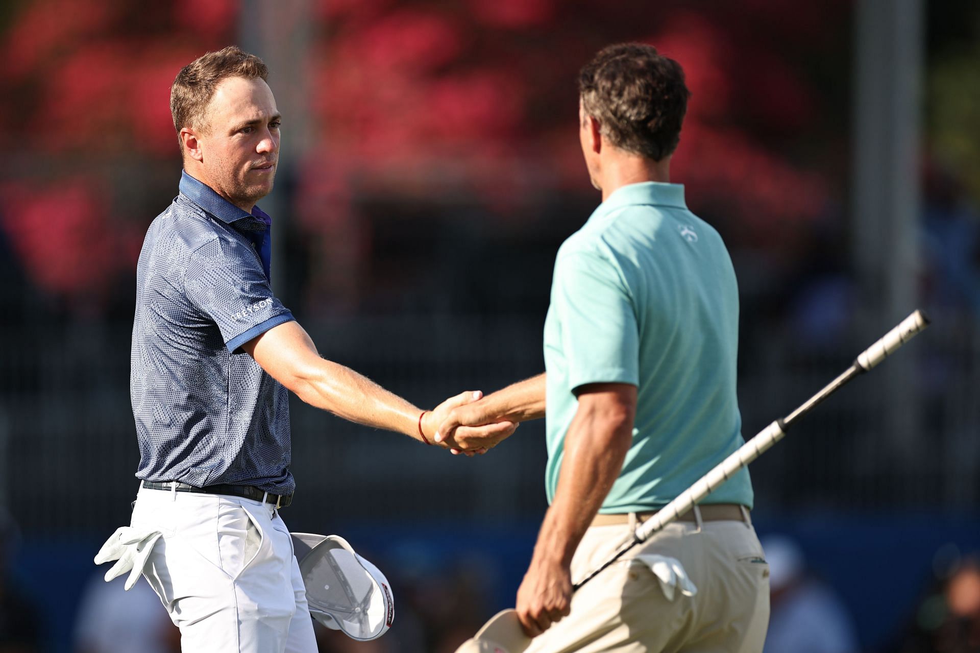 Justin Thomas shakes hands with Adam Scott on the 18th green during the second round of the Wyndham Championship