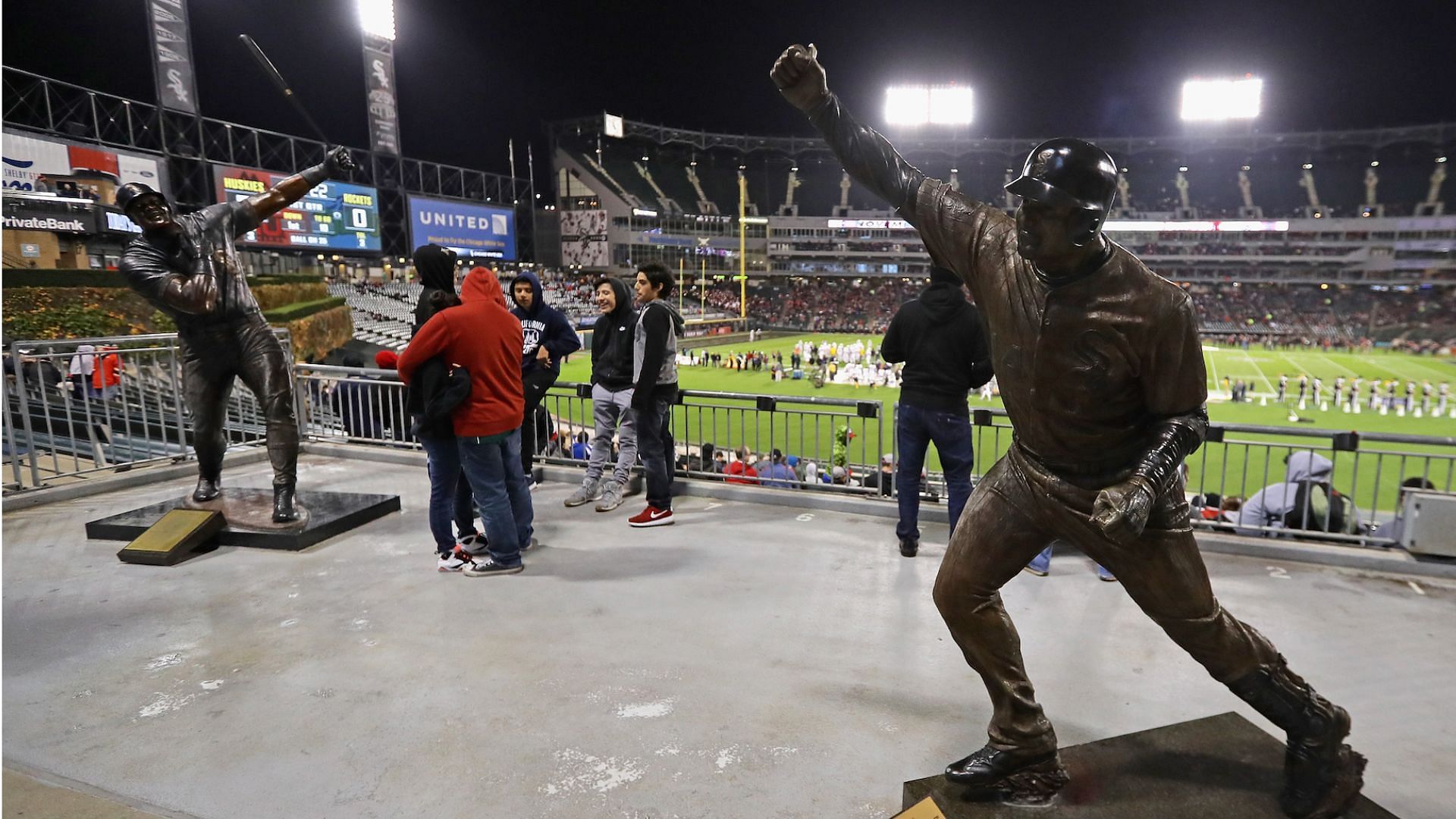 Fans stand in the outfield between statues of former White Sox players Frank Thomas (L) and Paul Konerko at Guaranteed Rate Field,