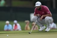 Jon Rahm lines up a putt on the eighth green during the third round of the Tour Championship