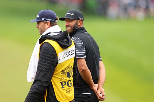 Dustin Johnson of the United States walks with his caddie Austin Johnson (Image via Getty)