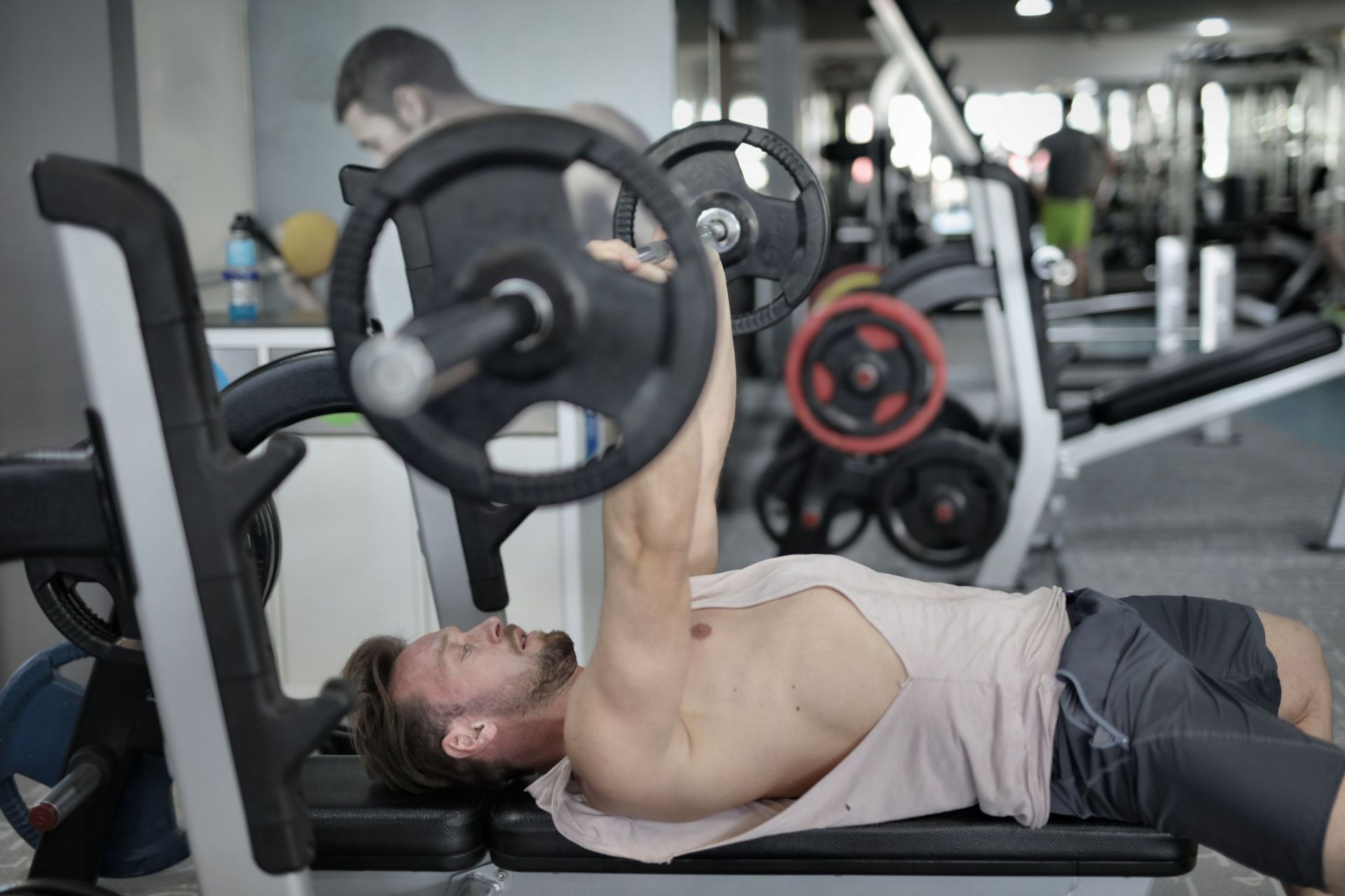 Dumbbell vs. barbell bench press (Image via Pexels/ Andrea Piacquadio)