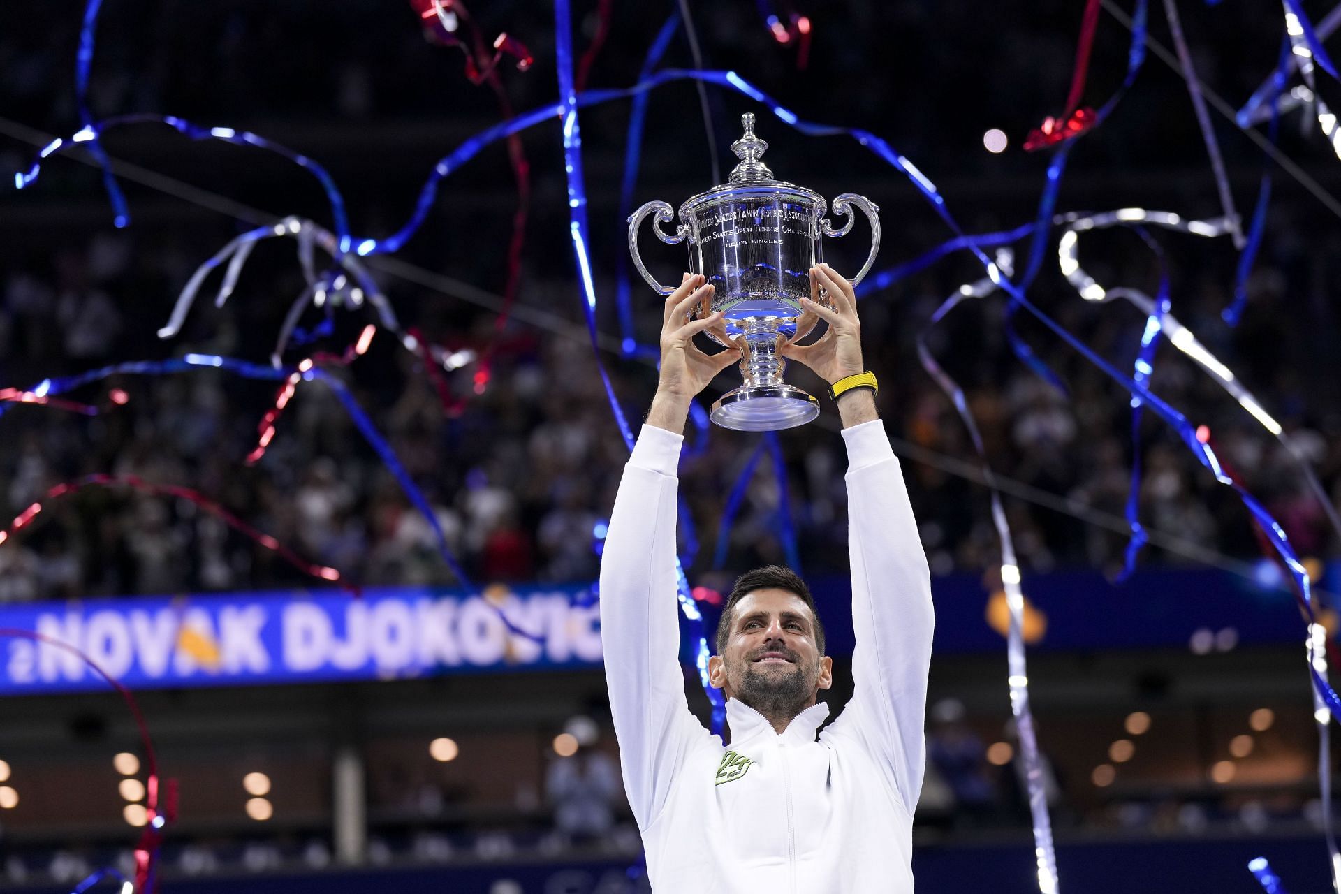 Novak Djokovic celebrating with the 2023 US Open trophy