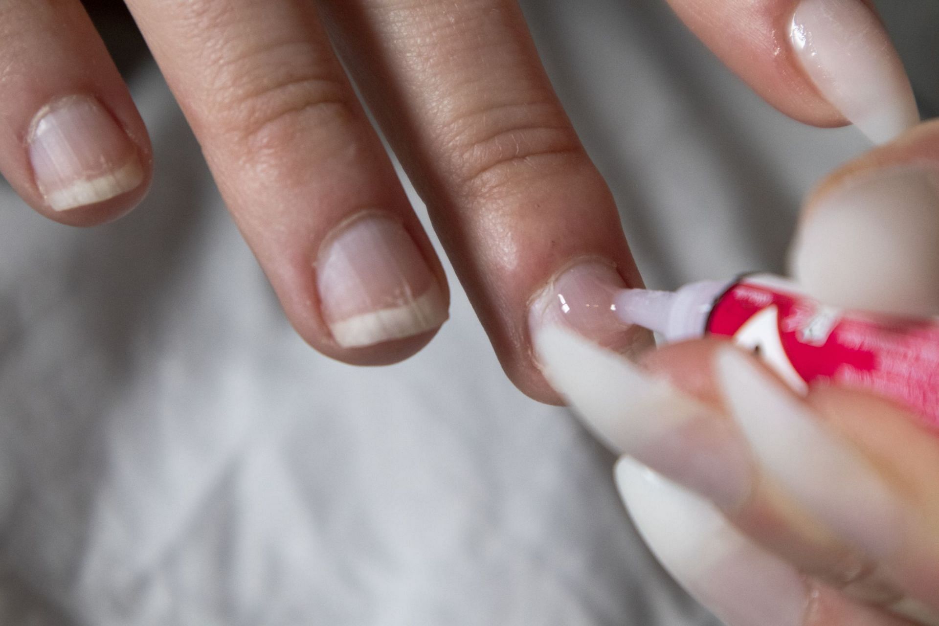 How to get nail glue off skin (Image via Getty Image/ Buket Topal)