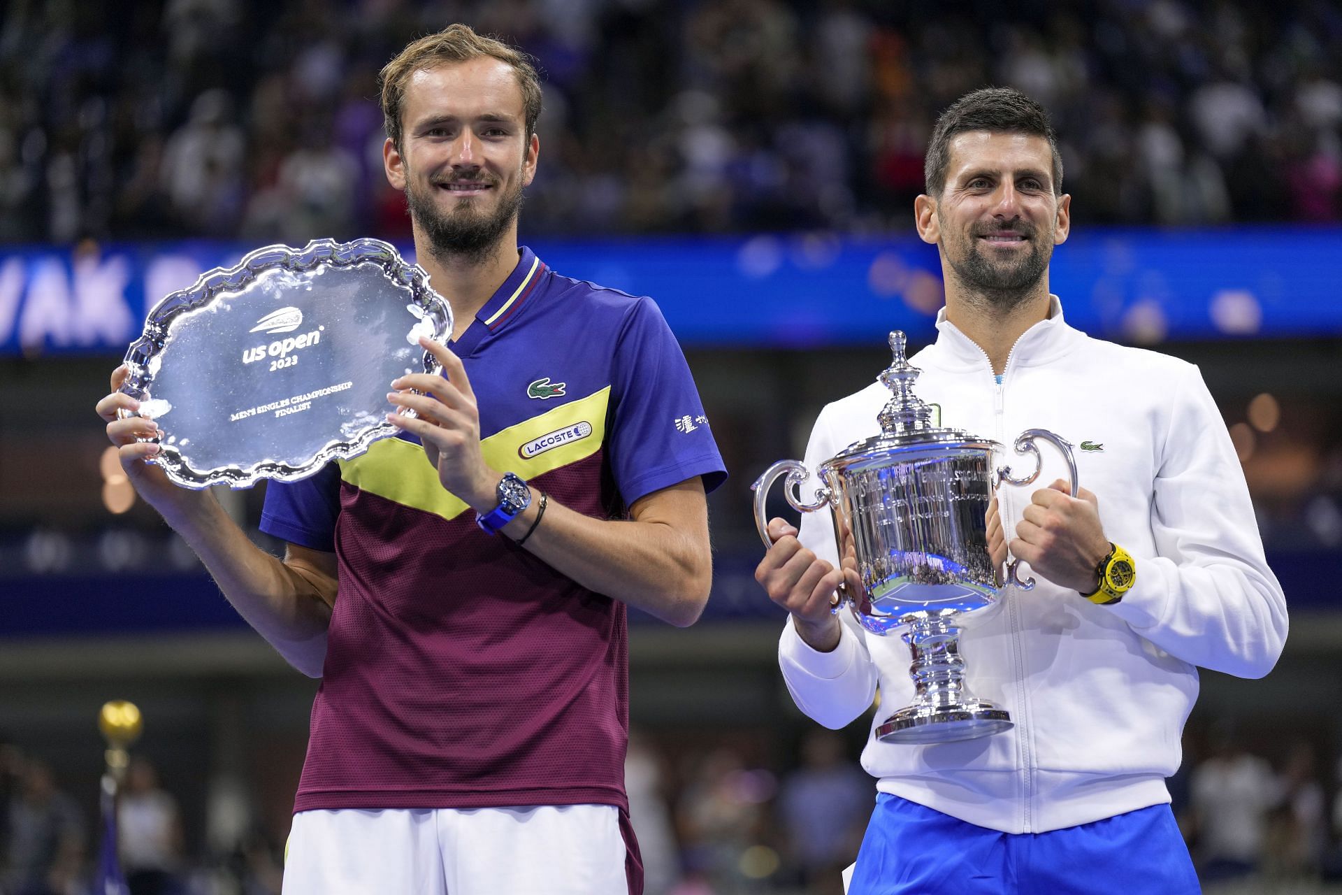 Daniil Medvedev, left, holds up the runner-up trophy as Novak Djokovic holds up the championship trophy after the men&#039;s singles final of the U.S. Open