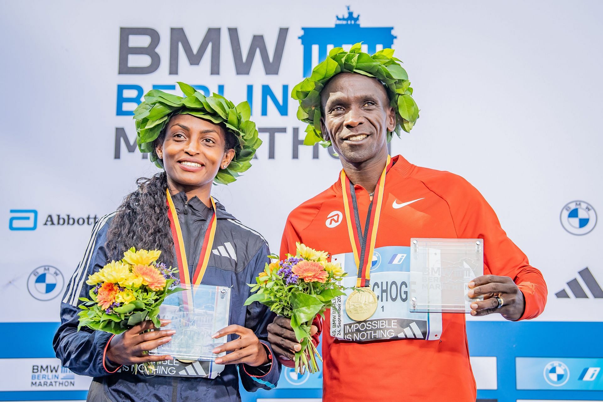 Tigist Assefa from Ethiopia and Eliud Kipchoge from Kenya celebrate their victories after the 2023 BMW Berlin-Marathon