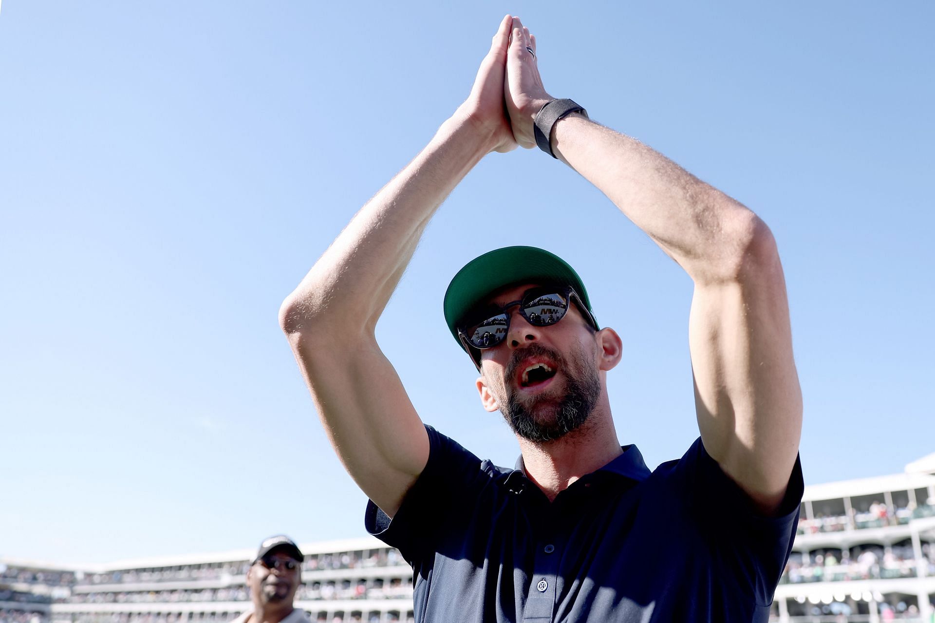 Michael Phelps reacts toward fans after playing the 16th hole prior to the WM Phoenix Open at TPC Scottsdale