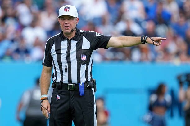 Referee Brad Rogers, left stands with replay official Durwood