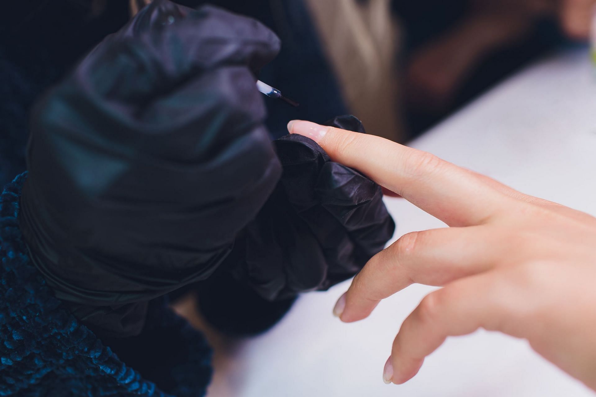 How to get nail glue off skin (Image via Getty Image/Vershinin)