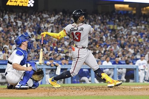 Atlanta Braves Ronald Acuna Jr., right, hits a grand slam as Los Angeles Dodgers catcher Will Smith watches in Los Angeles