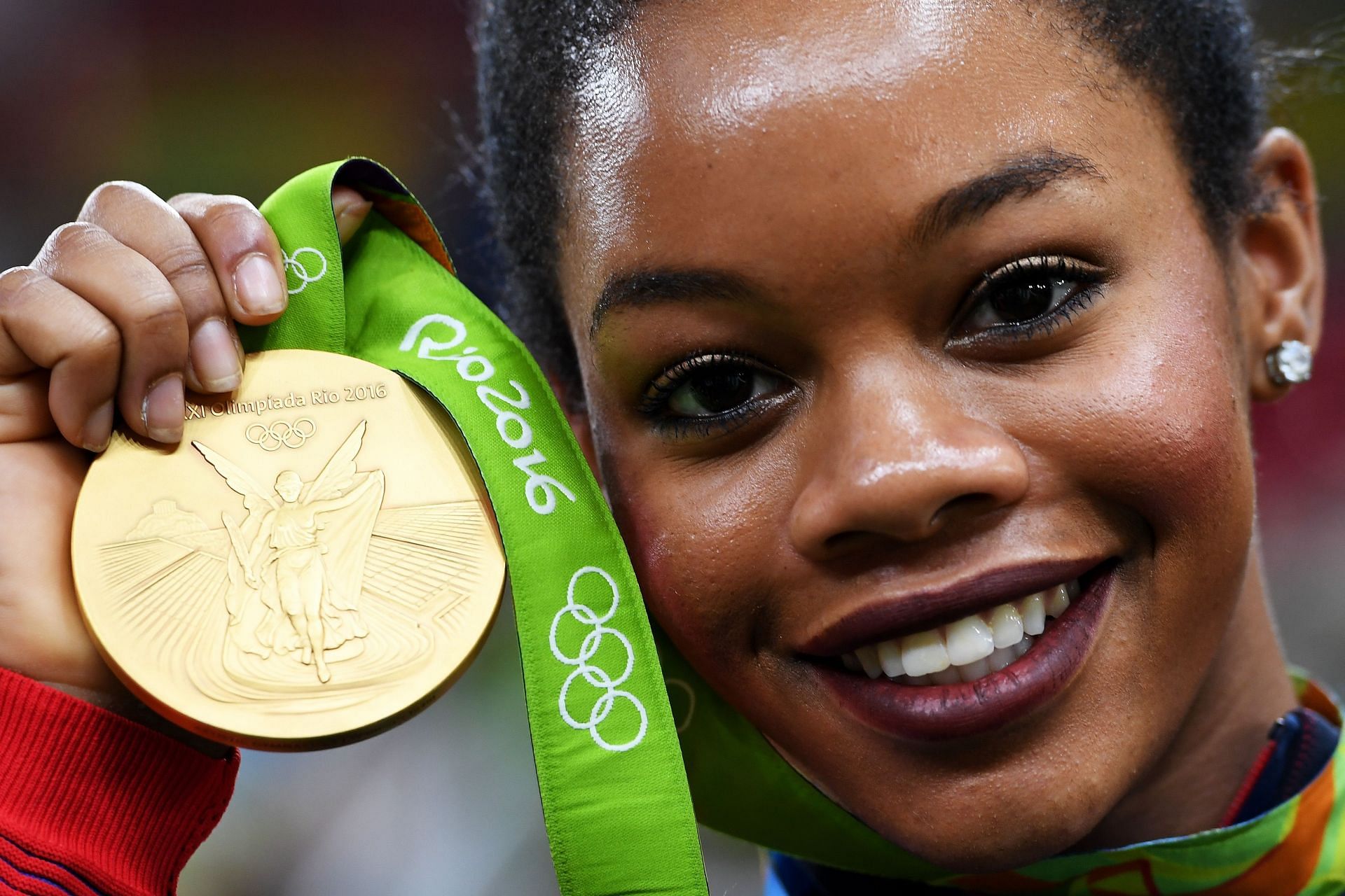 Gabrielle Douglas poses with her gold medal at the Rio 2016 Olympic Games.