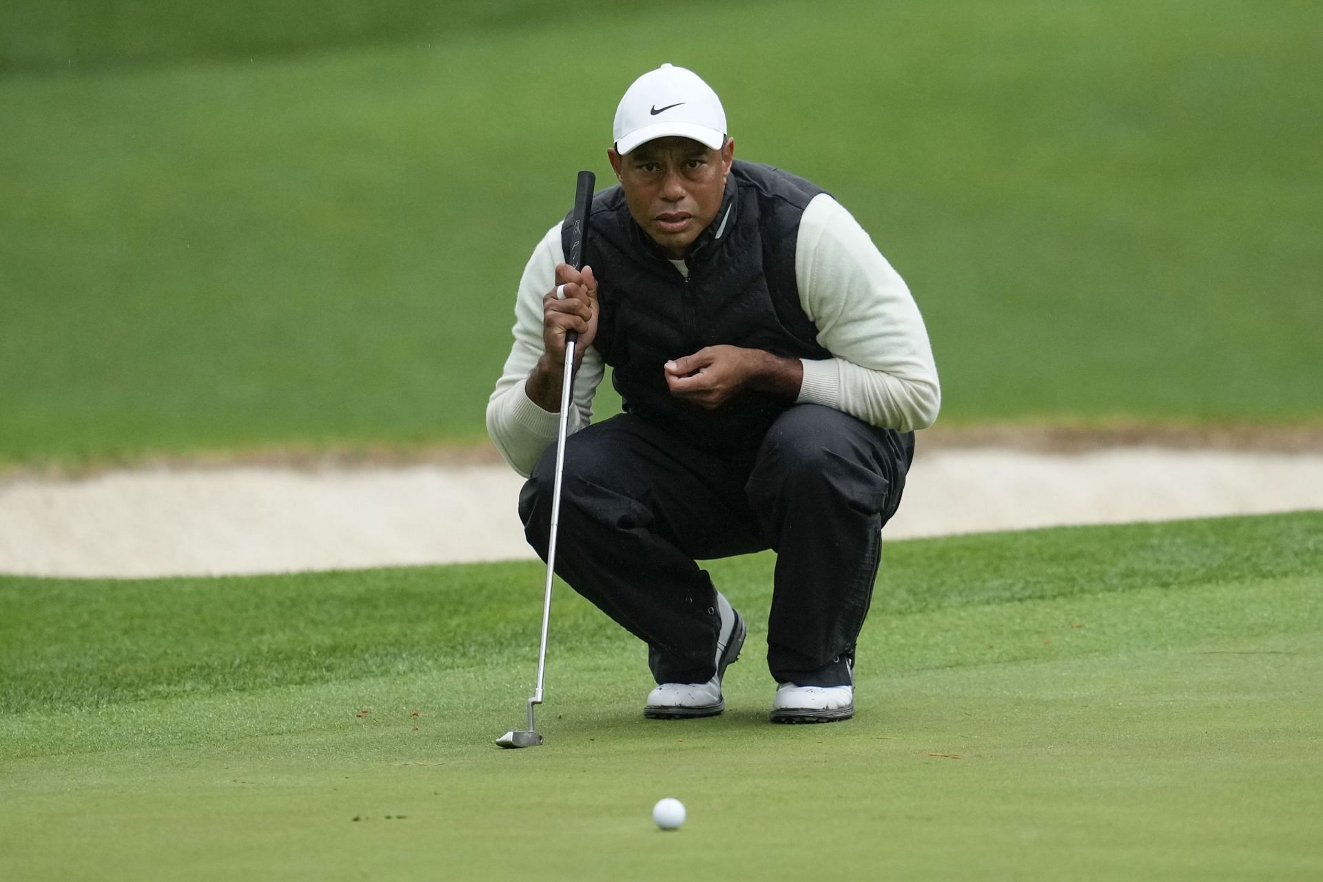 Tiger Woods lines up a putt on the 16th hole during the weather-delayed second round of the Masters golf tournament at Augusta National Golf Club