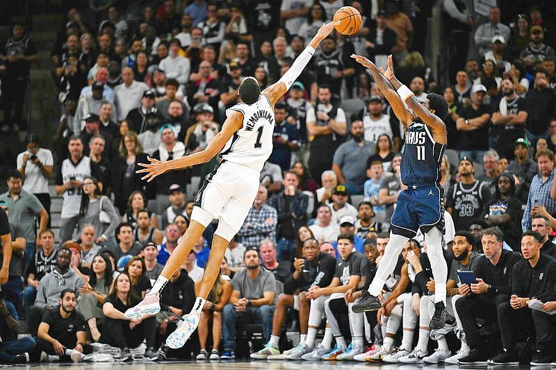 Victor Wembanyama (left) attempts to block Kyrie Irving