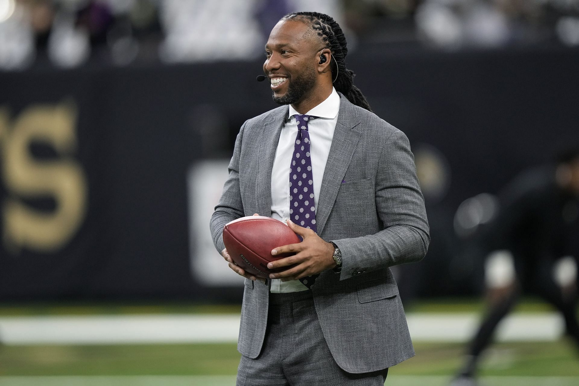 Larry Fitzgerald Jr. holds a ball on the field before an NFL football game between the New Orleans Saints and the Baltimore Ravens in New Orleans on November 7, 2022