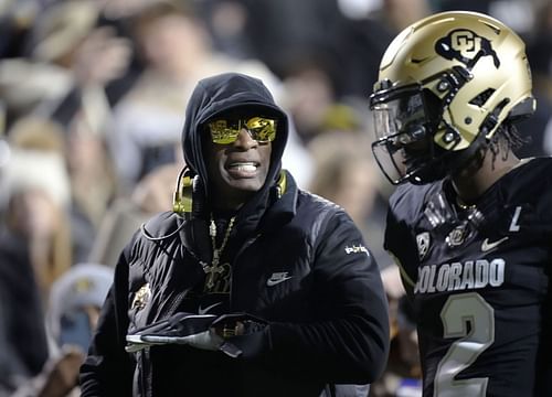 Stanford Colorado Football: Colorado coach Deion Sanders, left, talks to quarterback Shedeur Sanders, his son, during the first half of the team's NCAA college football game against Stanford on Friday, Oct. 13, 2023, in Boulder, Colo. (AP Photo/David Zalubowski)