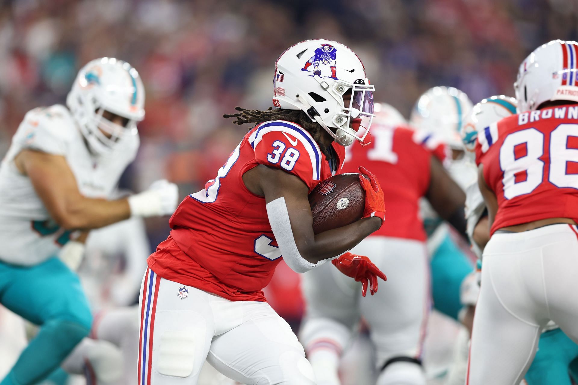 Rhamondre Stevenson carrying the ball vs the Miami Dolphins