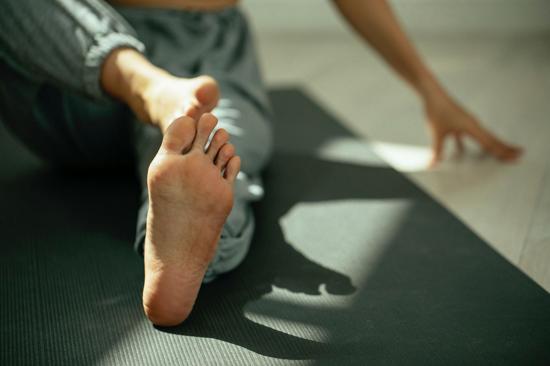 Ankle stretches before bedtime. (Image via Pexels/ Miriam Alonso)