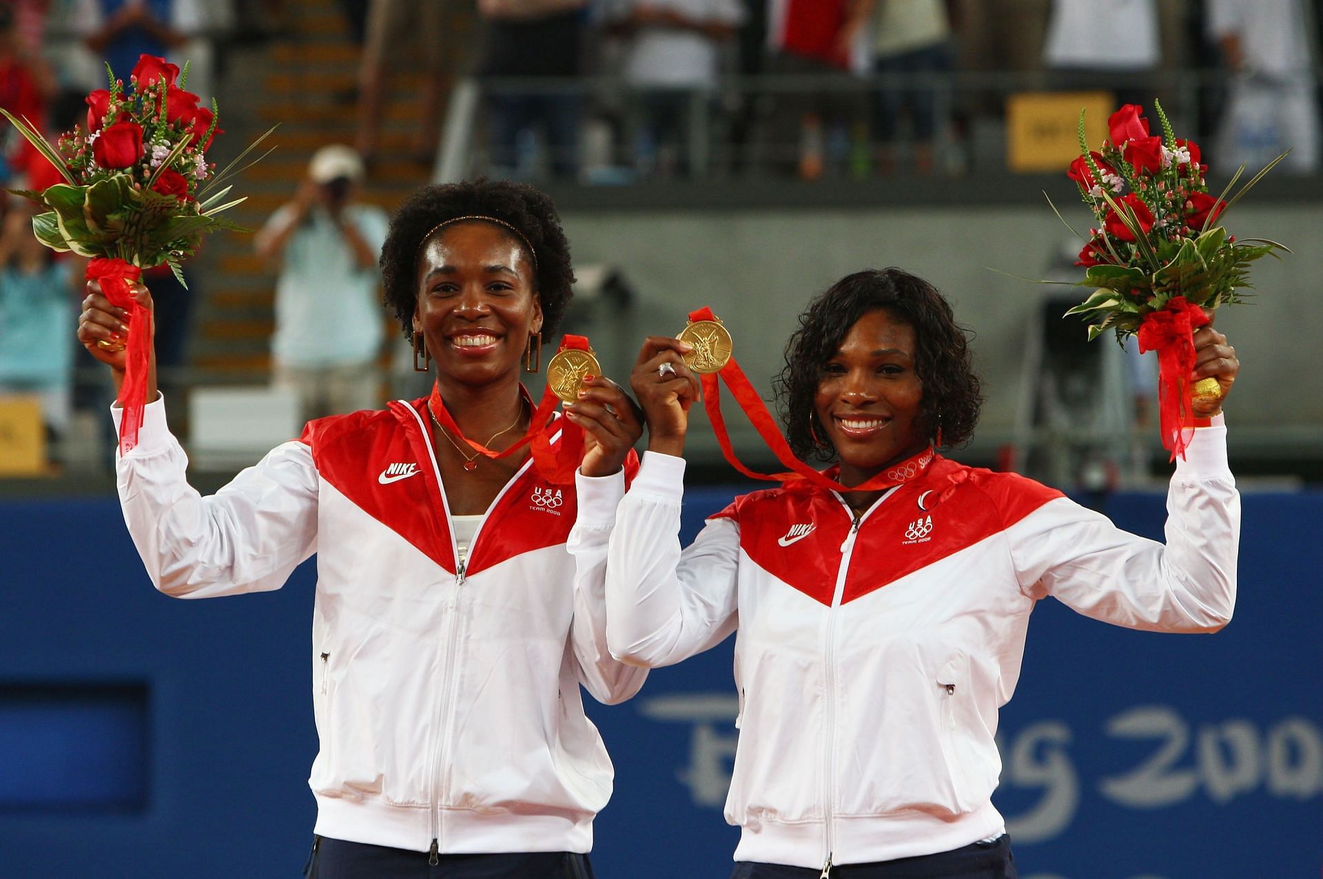 Venus and Serena Williams pose on the podium at the 2008 Beijing Olympics
