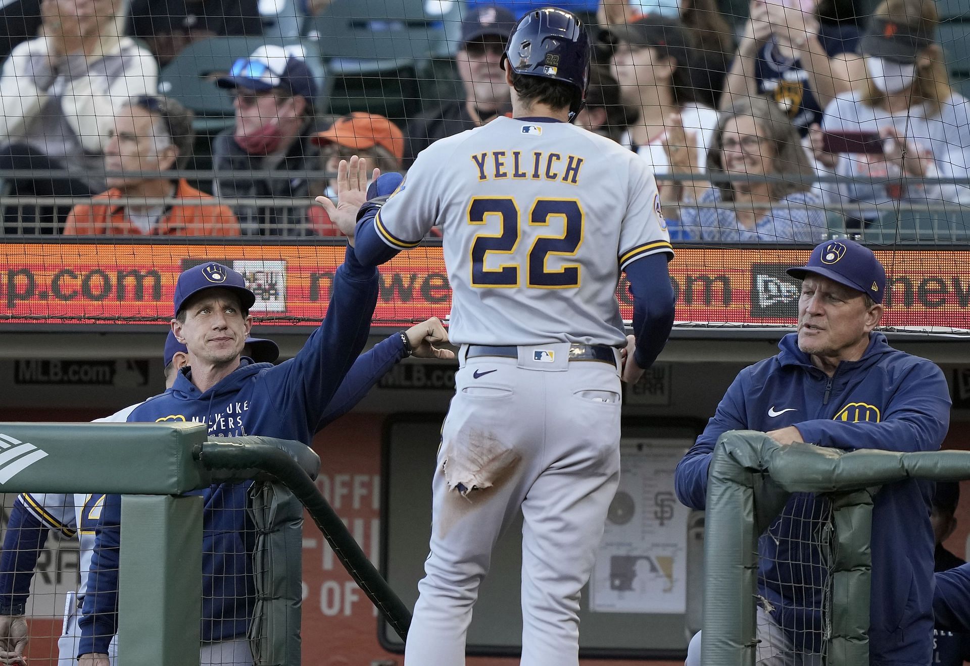Christian Yelich of the Milwaukee Brewers is congratulated by manager Craig Counsell after scoring against the San Francisco Giants