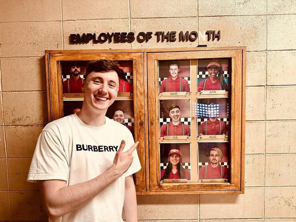 YouTuber Dawko posing in front of the Employee of the Month board (Image via Dawko/Instagram)