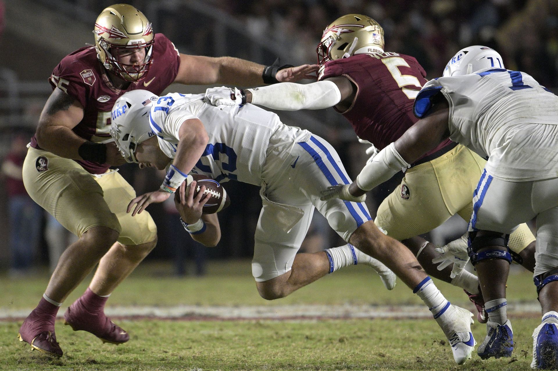 Duke Florida St Football: Duke quarterback Riley Leonard (13) is pulled down by his face mask by Florida State defensive lineman Braden Fiske (55) as defensive lineman Jared Verse (5) assists during the second half of an NCAA college football game, Saturday, Oct. 21, 2023, in Tallahassee, Fla. (AP Photo/Phelan M. Ebenhack)