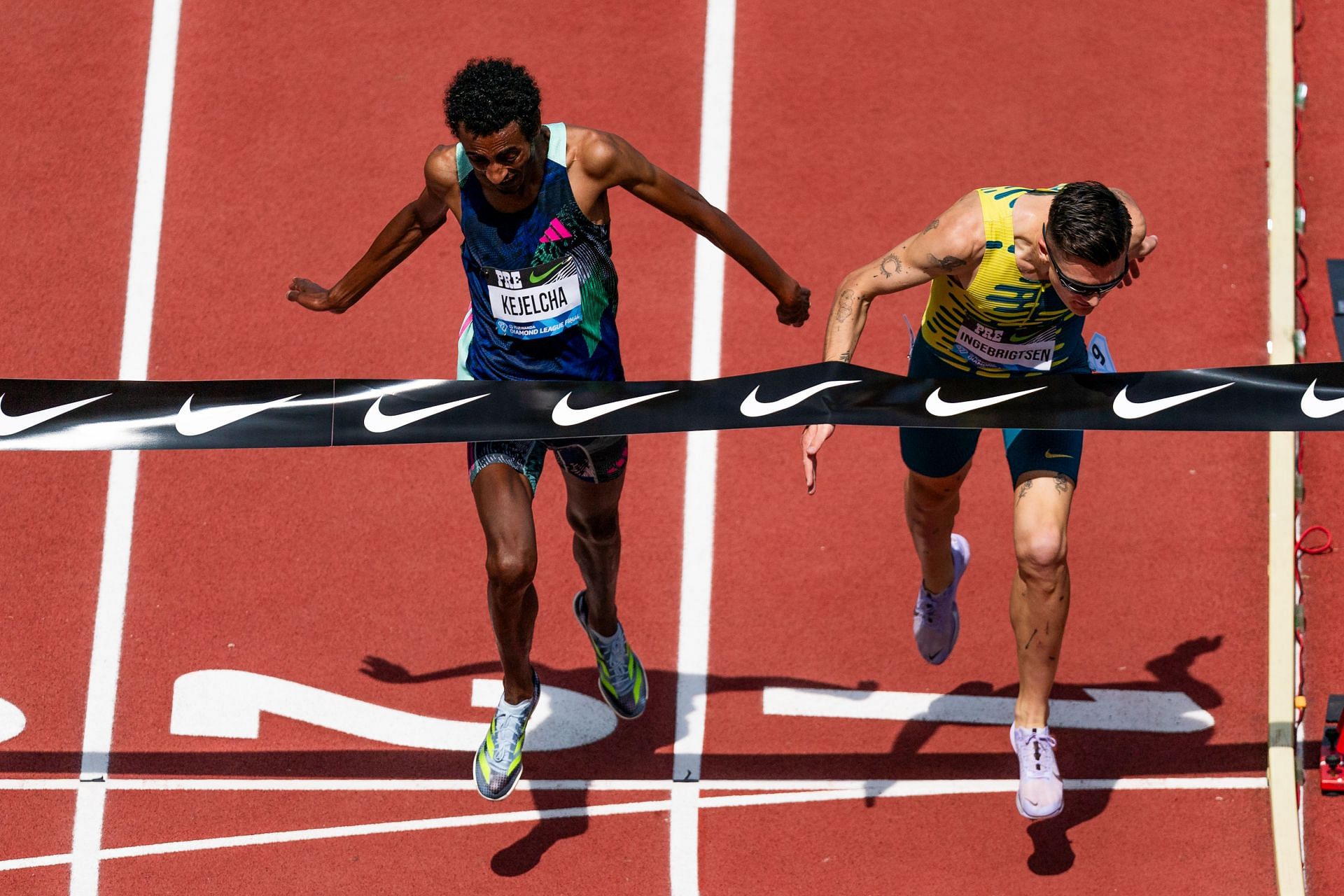 Yomif Kejelcha of Ethiopia (left) and Jakob Ingebrigtsen of Norway (right) lean towards the finish line in the Men&#039;s 3000m during the 2023 Prefontaine Classic and Wanda Diamond League Final at Hayward Field