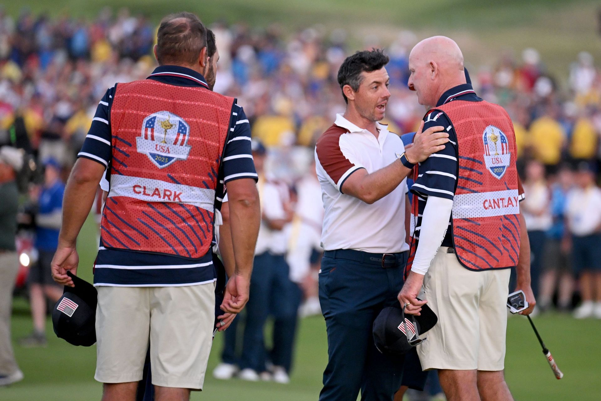 Rory McIlroy of Team Europe speaks with Joe LaCava on the 18th green during the Saturday afternoon fourball matches of the 2023 Ryder Cup (Image via Getty)