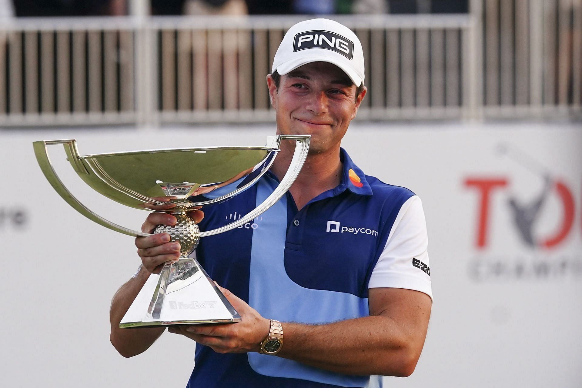 Viktor Hovland celebrates winning the Tour Championship golf tournament with the FedEx Cup trophy on the 18th green