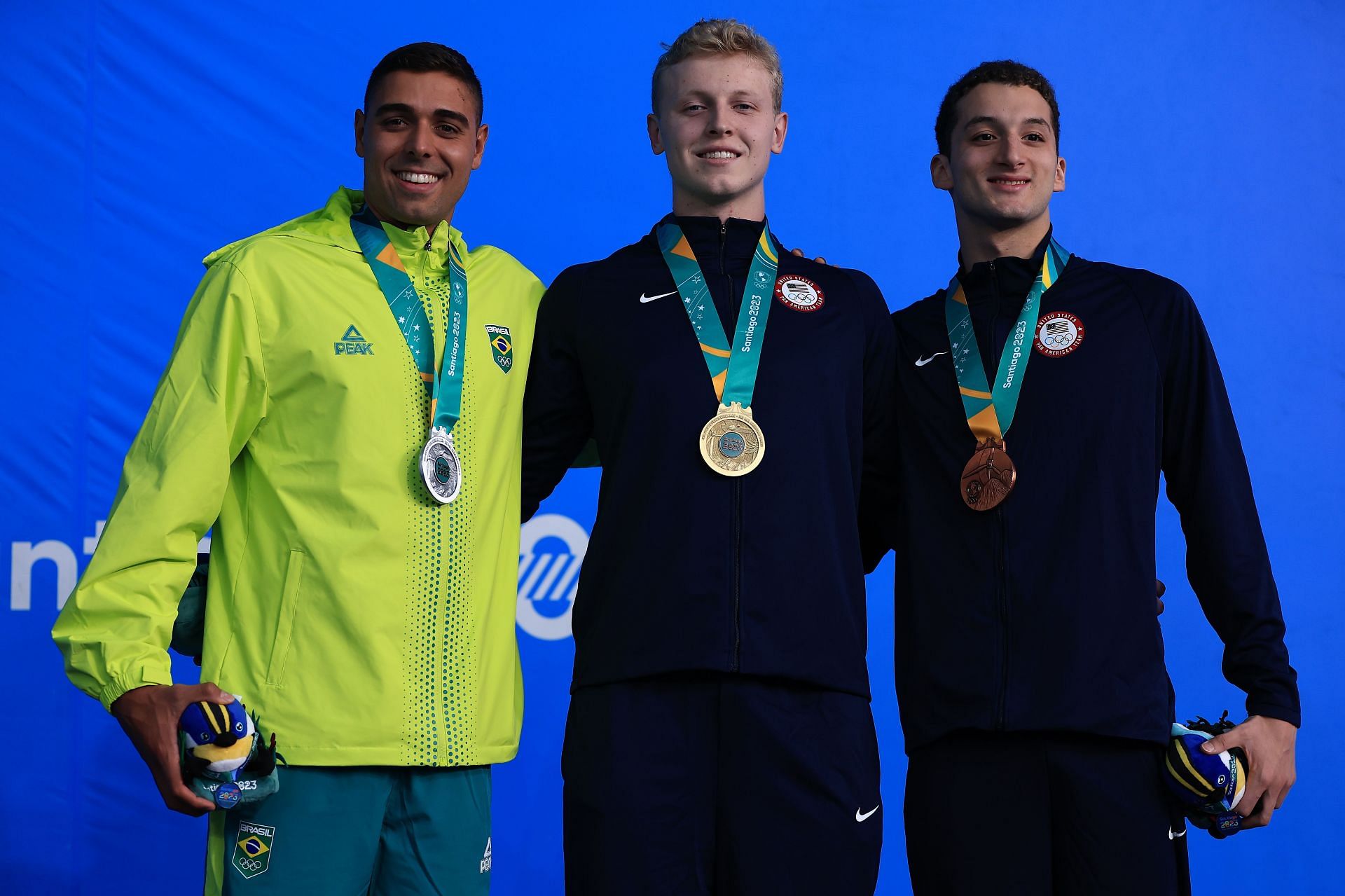 Vinicius Lanza, Lukas Davin Miller, and Arsenio Bustos pose on the podium of Men&#039;s 100m Butterfly at the 2023 Pan Am Games in Santiago, Chile.