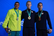 Vinicius Lanza, Lukas Davin Miller, and Arsenio Bustos pose on the podium of Men's 100m Butterfly at the 2023 Pan Am Games in Santiago, Chile.