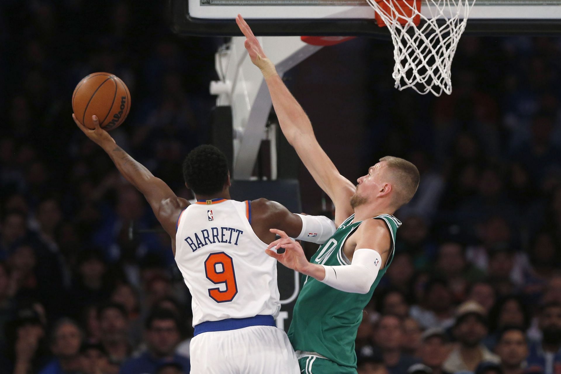 Kristaps Porzingis of the Boston Celtics defends RJ Barrett of the New York Knicks.