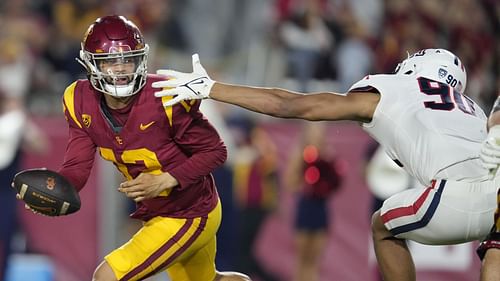 Arizona USC Football: Southern California quarterback Caleb Williams, left, evades the tackle attempt by Arizona defensive lineman Isaiah Ward during the first half of an NCAA college football game Saturday, Oct. 7, 2023, in Los Angeles. (AP Photo/Marcio Jose Sanchez)