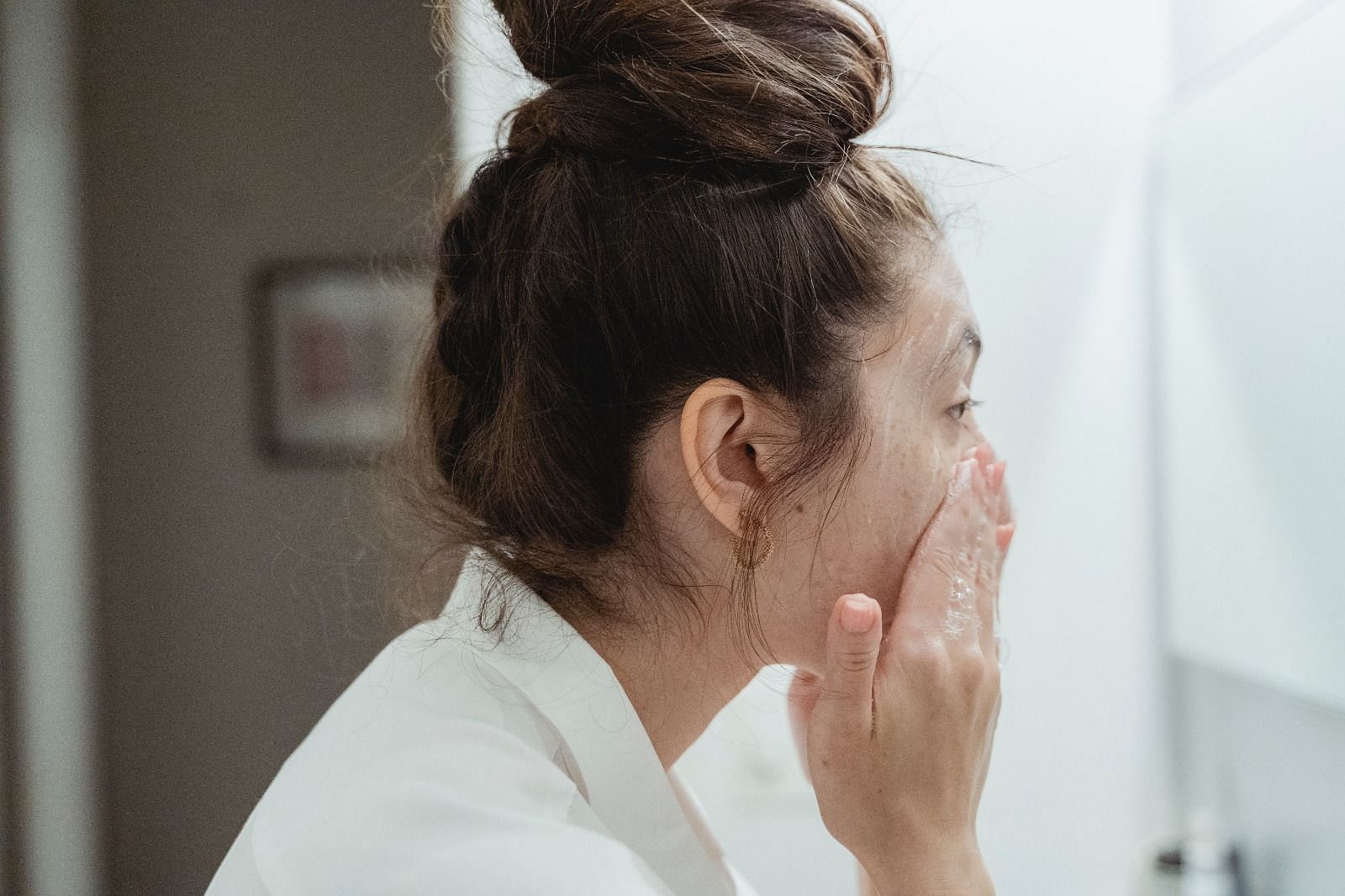 Washing face with cold water (Image via Pexels/Miriam Alonso)