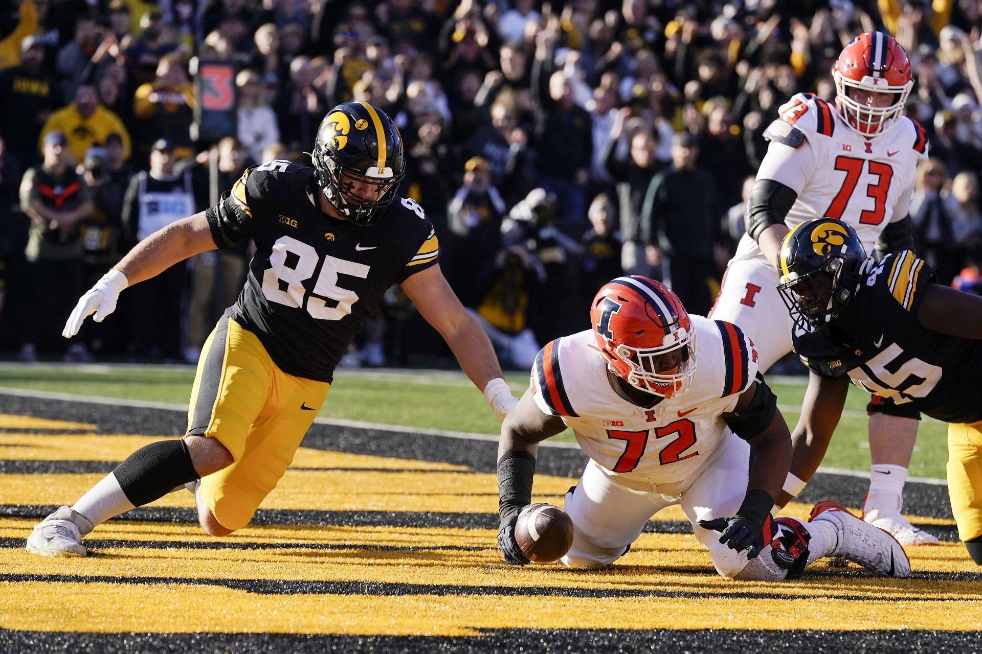 Illinois Iowa Football: Illinois offensive lineman Zy Crisler (72) recovers a fumble in the end zone in front of Iowa defensive lineman Logan Lee (85) during the first half of an NCAA college football game, Saturday, Nov. 18, 2023, in Iowa City, Iowa. (AP Photo/Charlie Neibergall)