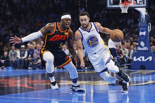 Steph Curry of the Golden State Warriors being guarded by Lu Dort of the OKC Thunder.