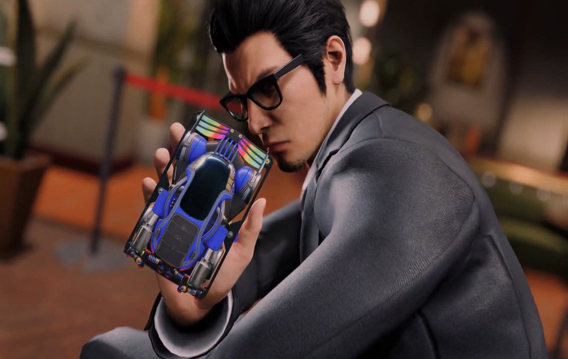 Screenshot from Yakuza Gaiden showcasing Kiryu holding a toy racing car