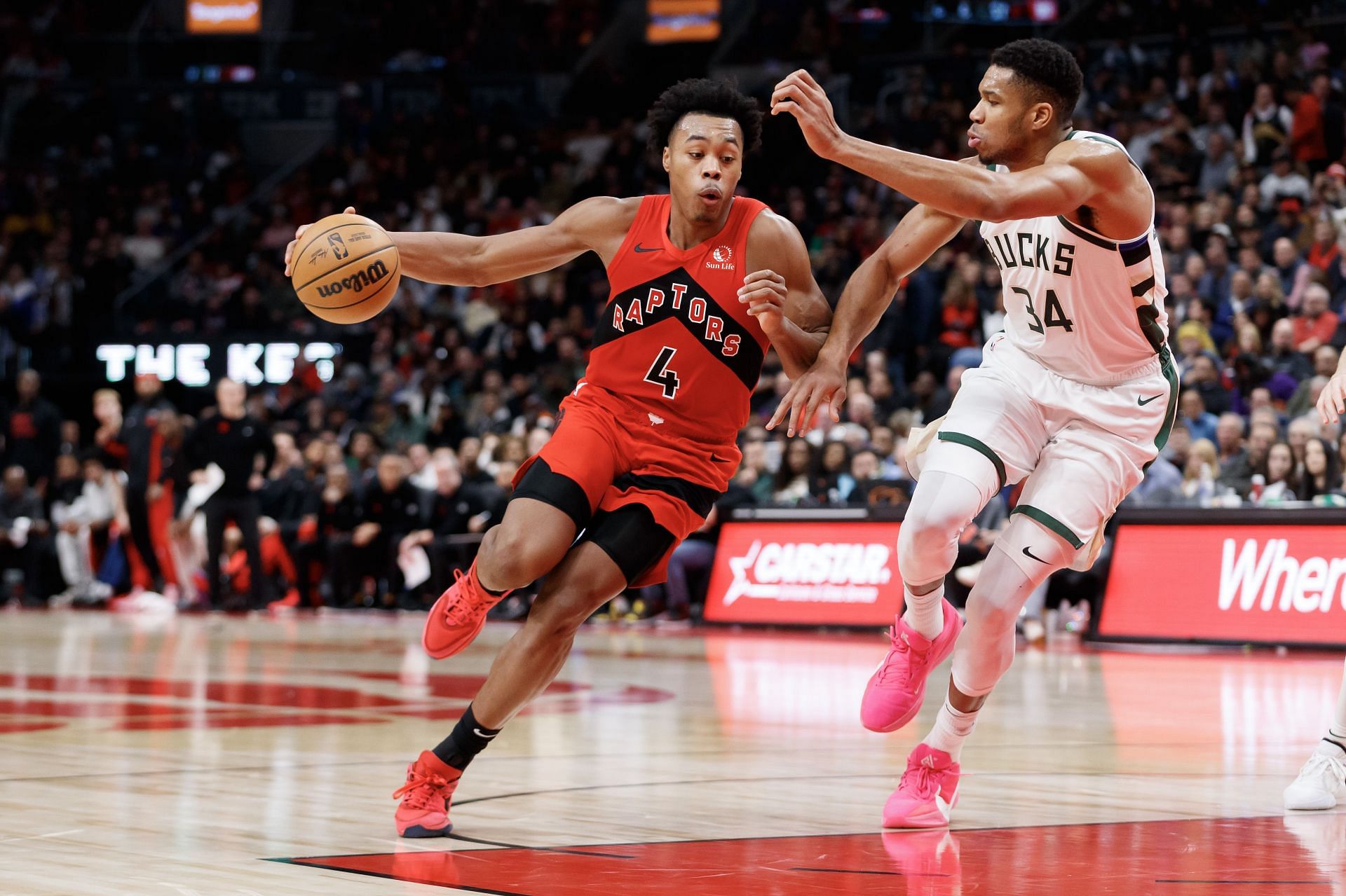 Scottie Barnes of the Toronto Raptors drives against Giannis Antetokounmpo of the Milwaukee Bucks