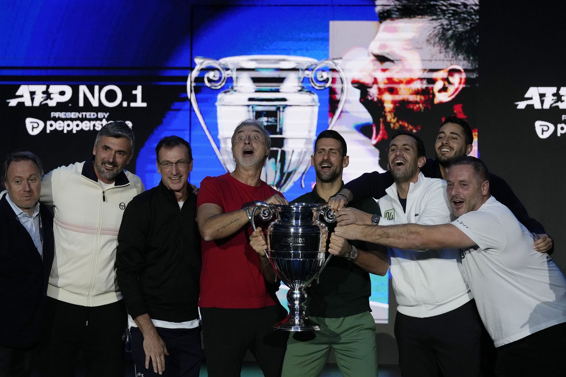 Djokovic flanked by his team members after the year-end World No. 1 trophy presentation