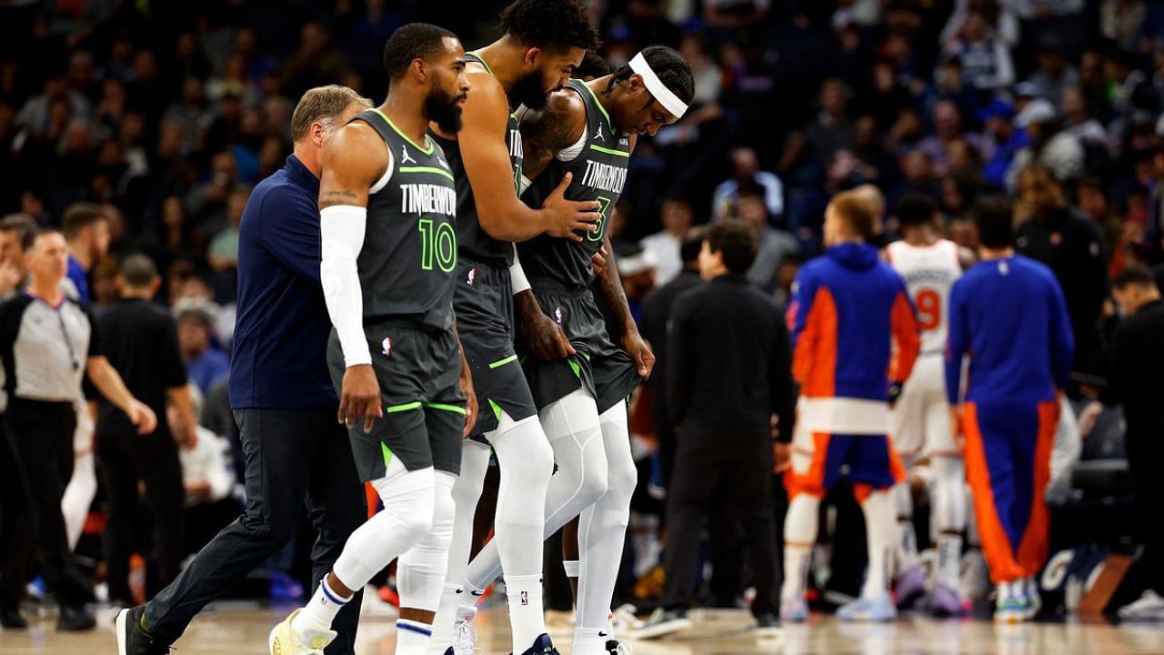 Minnesota Timberwolves forward Jaden McDaniels is helped to the bench by teammate Karl-Anthony Towns after spraining his ankle against the New York Knicks on Monday.