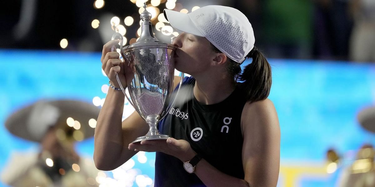Iga Swiatek pictured with her maiden WTA Finals trophy