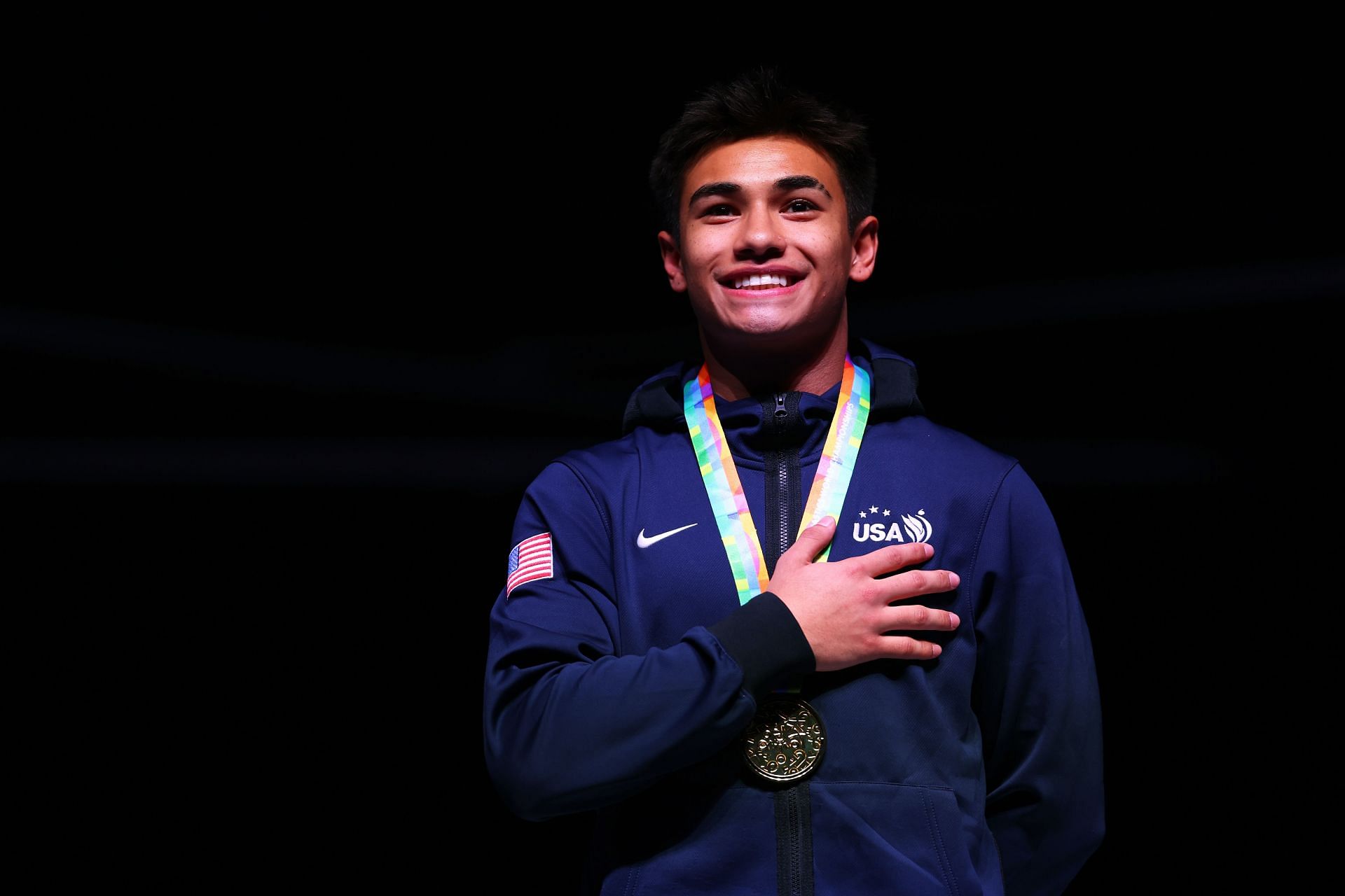 Ruben Padilla of the USA celebrates on the podium after winning the gold medal in the DMT on day three of the 37th FIG Trampoline Gymnastics World Championships at Utilita Arena on November 11, 2023, in Birmingham, England