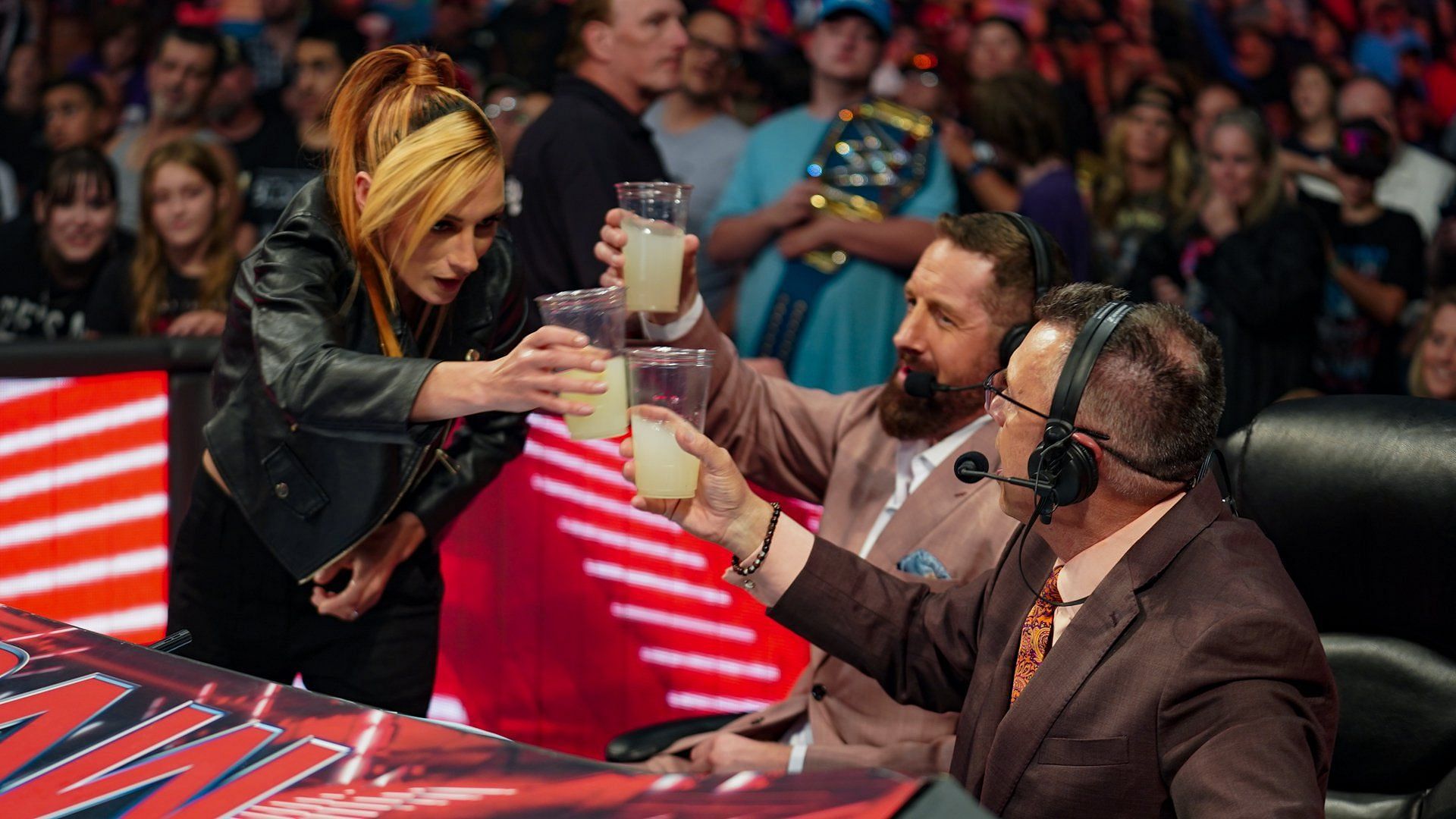 Becky Lynch (left), Wade Barrett (middle), and Michael Cole (right)
